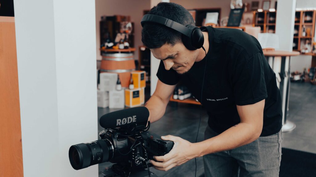 Filmcrew-Mitglied mit Kamera und Kopfhörern beim Dreh eines Videotestimonials