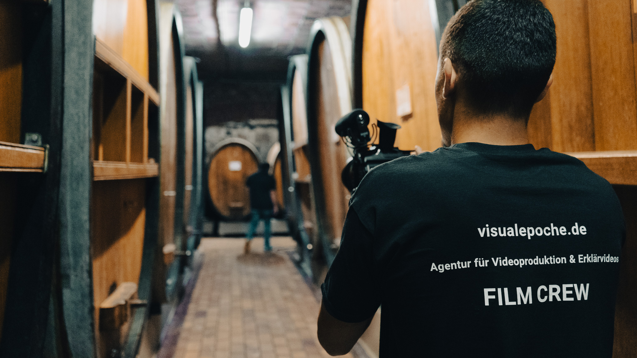 Filmcrew bei der Produktion eines Messefilms in einer Location mit großen Holzfässern – Visual Epoché Videoproduktion